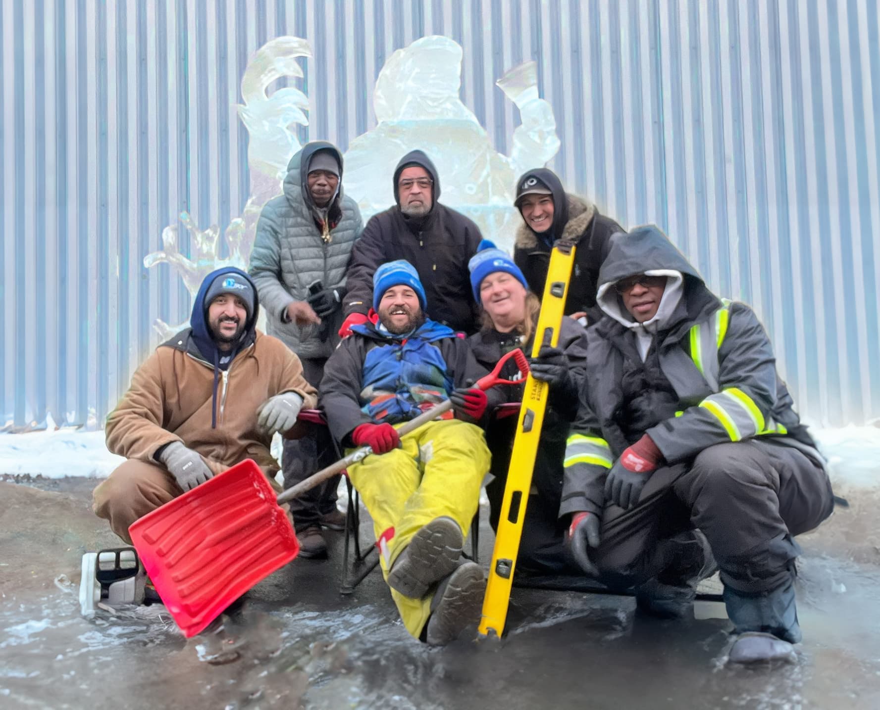 The Ice Boy team in front of a multi-block ice sculpture in winter gear